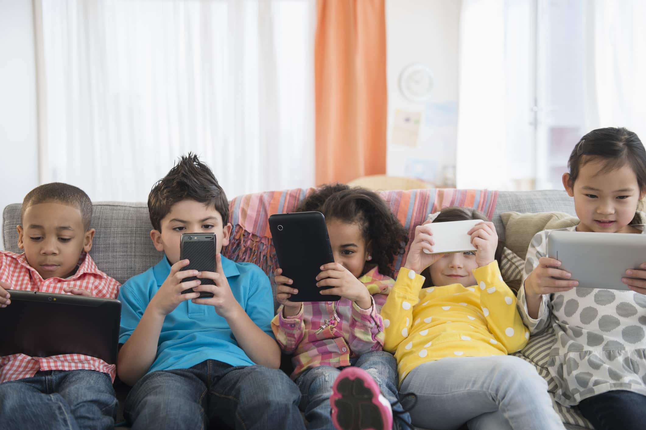 Enfants utilisant des téléphones intelligents et des tablettes.